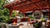 Custom Big Timber pergola with an outdoor kitchen, fire pit, and lounge in a landscaped backyard.